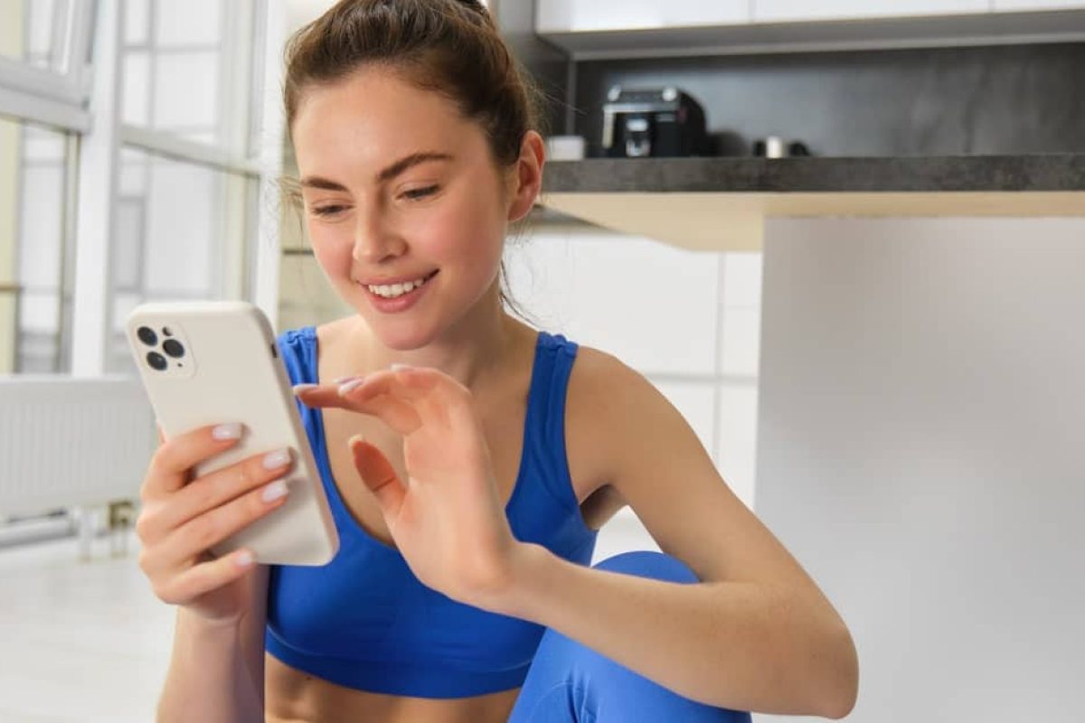 Femme en tenue de sport consultant son smartphone pour suivre des conseils santé et bien-être en ligne